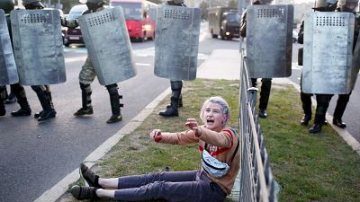 A woman reacts as she sits in front of law enforcement officers during a rally to protest against the presidential inauguration in Minsk on September 23, 2020. A woman reacts as she sits in front of law enforcement officers during a rally to protest against the presidential inauguration in Minsk on September 23, 2020.