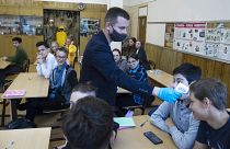 Преподаватель измеряет температуру ученику в московской школе.