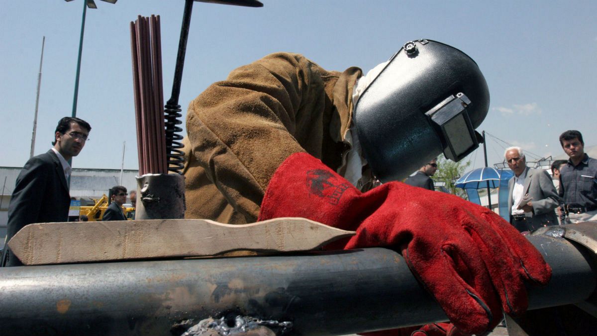 Iranian worker Amir Ghanbari welds a gas pipe in the Tehran's Oil, Gas, Petrochemical Show, Iran
