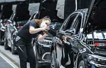 A Mercedes-Benz employee is working on a fuel cap cover for an S-Class at the "Factory 56" plant in Sindelfingen, Germany