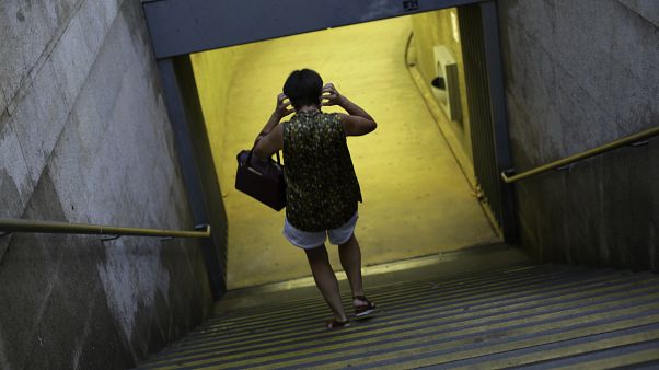 Uma mulher coloca uma máscara à entrada do Metro em Lisboa Uma mulher coloca uma máscara à entrada do Metro em Lisboa