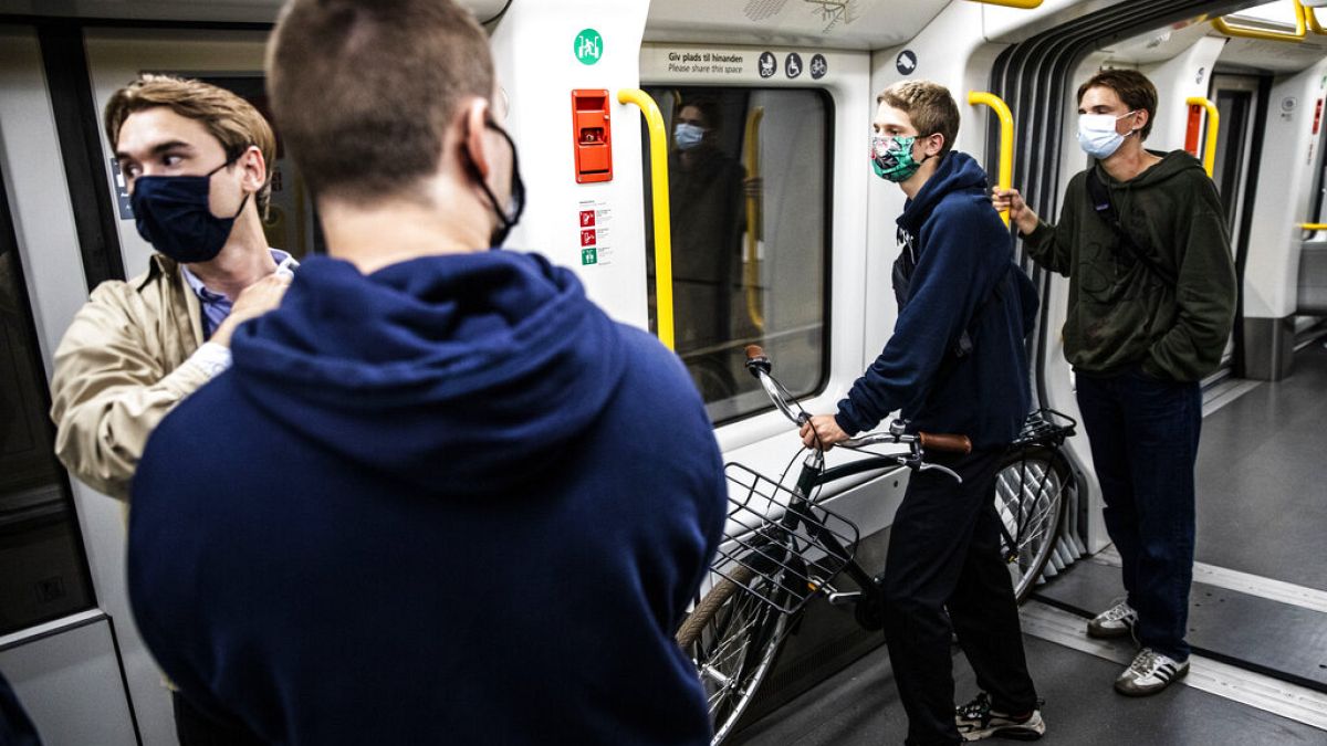 People wearing face masks ride a metro in Copenhagen, Denmark
