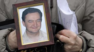 FILE - In this Nov. 30, 2009, file photo a portrait of lawyer Sergei Magnitsky, who died in jail, is held by his mother Nataliya Magnitskaya in Moscow