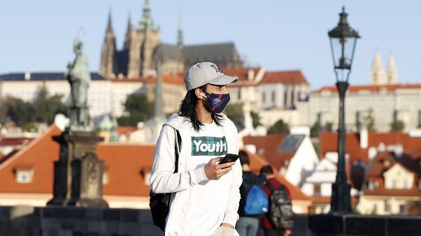 Maszkban sétáló fiatal Prágában Maszkban sétáló fiatal Prágában