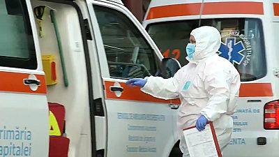 Un sanitario, equipado con un traje de protección, en Bucarest
