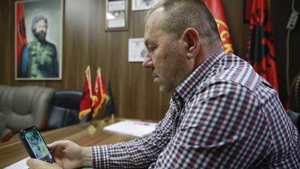 Hysni Gucati head of the War Veterans Organization of the Kosovo Liberation Army looks at a photo of former Kosovo Liberation Army commander Salih Mustafa after his arrest.
