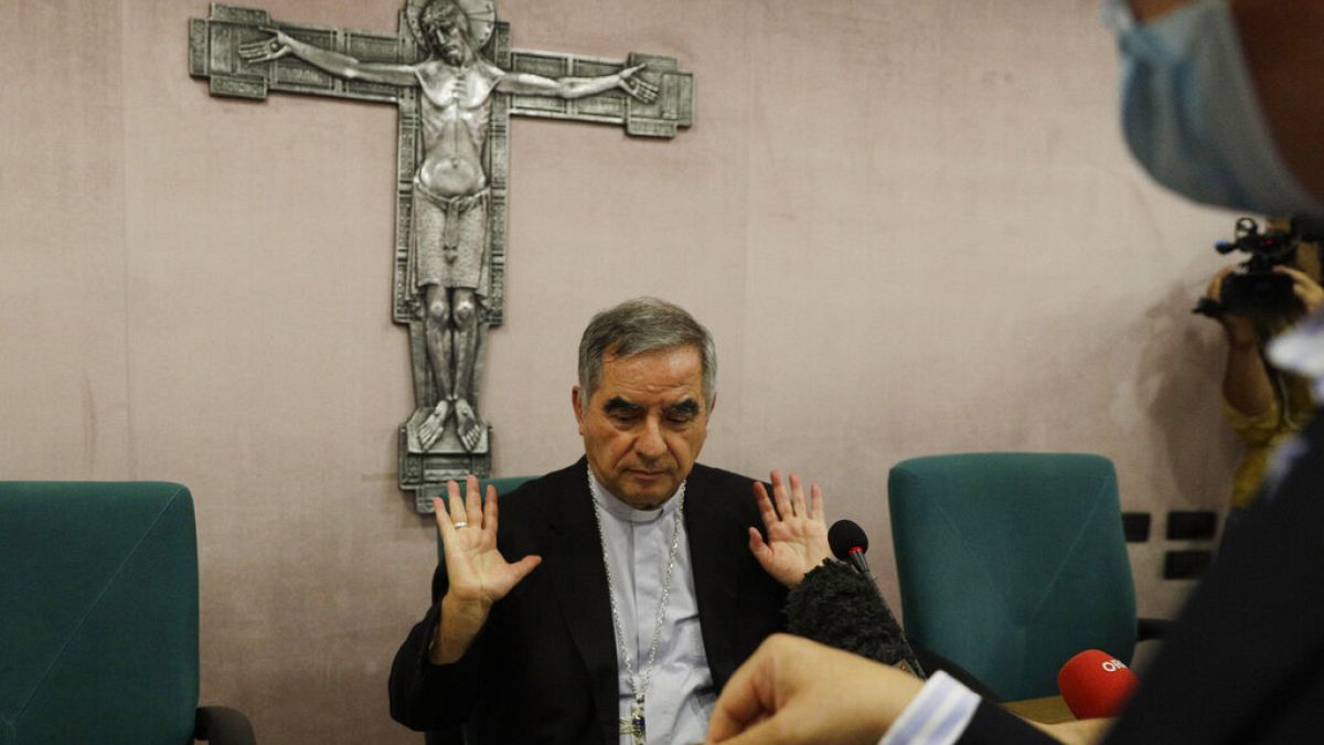 Angelo Becciu talks to journalists on Friday, a day after he resigned and renounced his rights as a cardinal 
