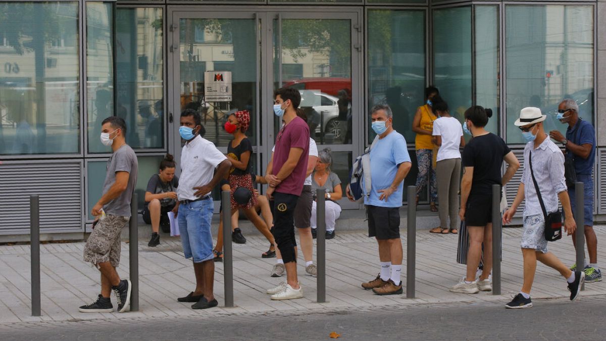 People wait in a line to get tested for COVID-19 outside a laboratory in Paris, Saturday, Aug 8, 2020. 
