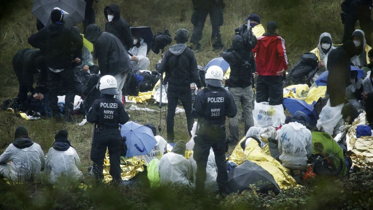 Activists are surrounded by police on the Garzweiler power plant grounds in Grevenbroich, western Germany, Saturday, Sept. 26, 2020.