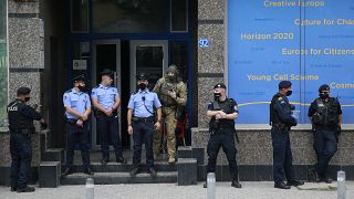 Kosovo police guard the entrance of the offices of a war veterans association in Kosovo, in Pristina, Friday, Sept. 25, 2020.