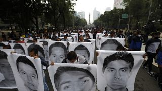 Estudiantes universitarios se manifiestan en Ciudad de México con carteles con los rostros de los estudiantes desaparecidos de Ayotzinapa