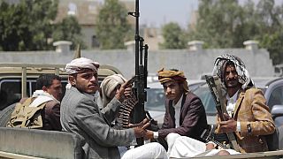 FILE - In this Aug. 22, 2020 file photo, tribesmen loyal to Houthi rebels hold their weapons as they ride in a vehicle.