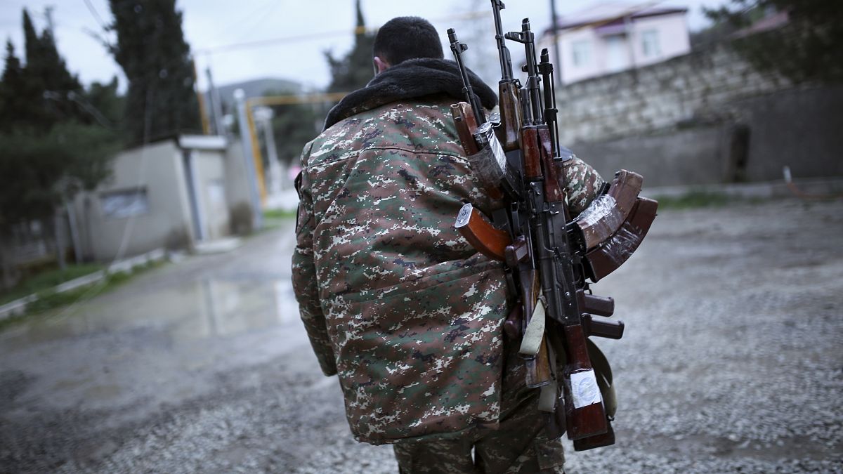 Un combattente di origini armene con dei Kalashnikov a Martakert, nella regione separatista del Nagorno-Karabakh. Foto del 2016