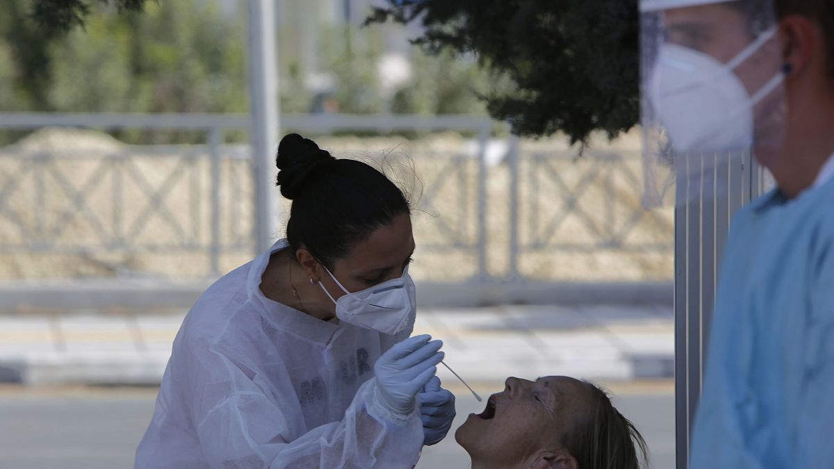 A health worker carries out a COVID-19 test of a resident of Larnaca