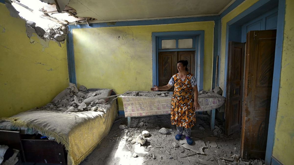 A woman shows damage to her house after shelling on the Armenia-Azerbaijan border in July 2020.