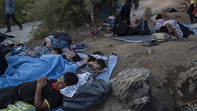 Migrants sleep outside the burned Moria refugee camp, on the northeastern Aegean island of Lesbos, Greece, on Wednesday, Sept. 9, 2020. 