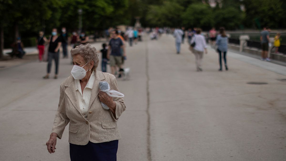 Una anciana, usando una mascarilla para prevenir la propagación del coronavirus, da un paseo en el parque del Retiro en Madrid, España, el lunes 1 de junio de 2020.