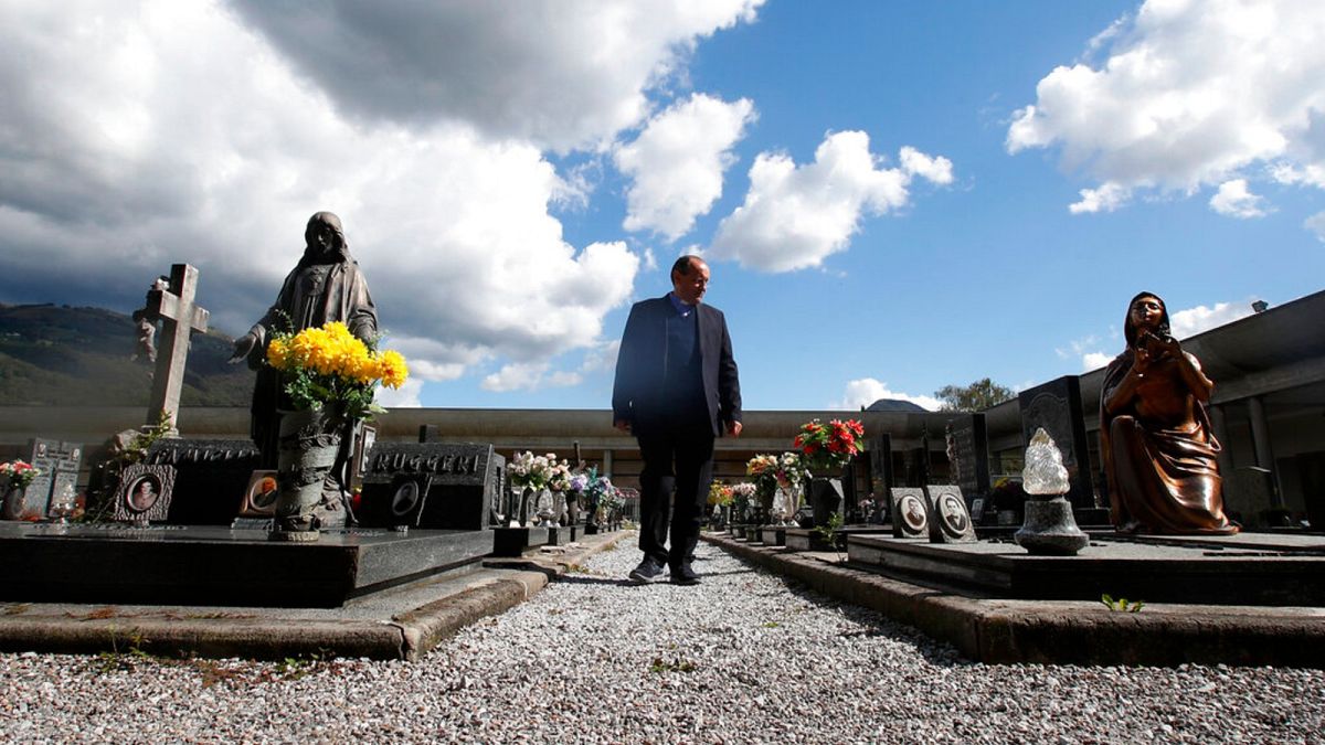 Rev. Mario Carminati walks in a cemetery in Casnigo, near Bergamo, Italy, Sunday, Sept. 27, 2020. 