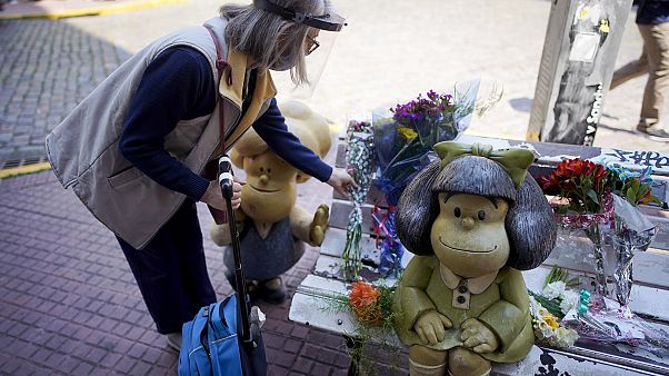 Una mujer deposita un ramo de flores en el banco de Mafalda en Buenos Aires Una mujer deposita un ramo de flores en el banco de Mafalda en Buenos Aires