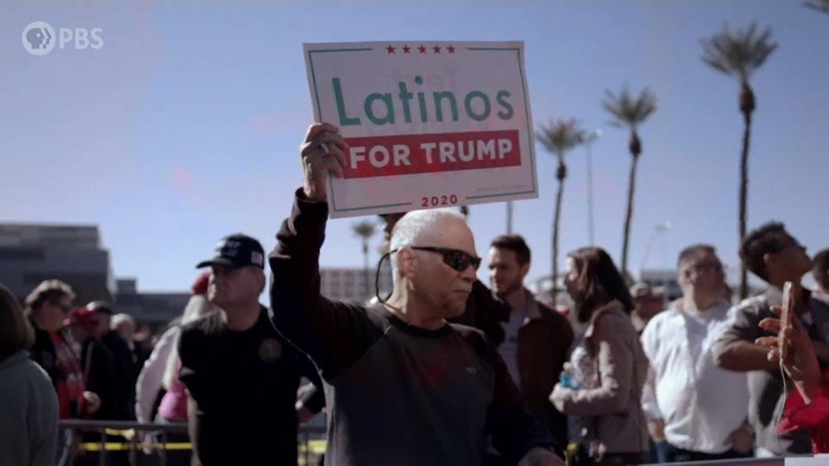 Un hombre porta un cartel con la leyenda "Latinos por Trump"
