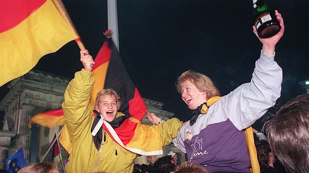 Berliner youths wave German flags during the celebration of the country's reunification at the Brandenburg Gate, Berlin. October 3, 1990 Berliner youths wave German flags during the celebration of the country's reunification at the Brandenburg Gate, Berlin. October 3, 1990
