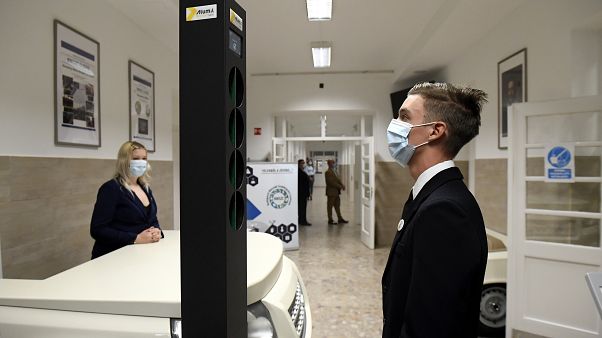 Diák a Budapesti Műszaki Szakképzési Centrumban felállított digitális testhőmérő kapu előtt 2020. október 1-jén. Diák a Budapesti Műszaki Szakképzési Centrumban felállított digitális testhőmérő kapu előtt 2020. október 1-jén.