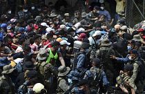 Los migrantes hondureños fuerzan el cordón de policías y militares en la frontera
