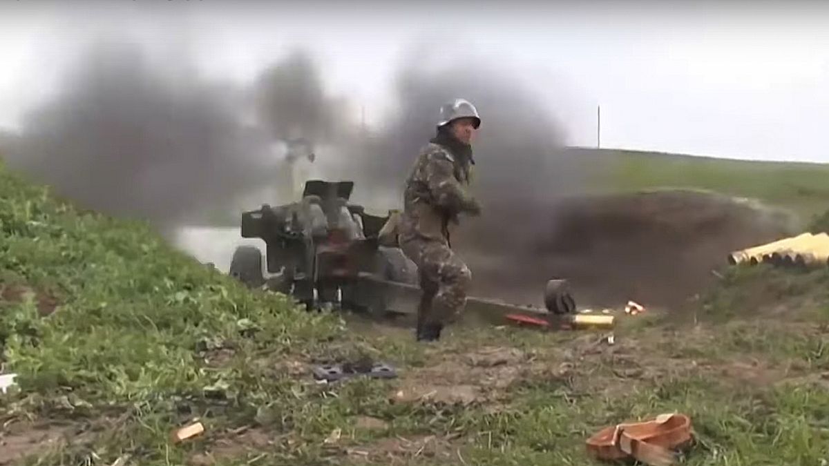 an Armenian serviceman fires a cannon