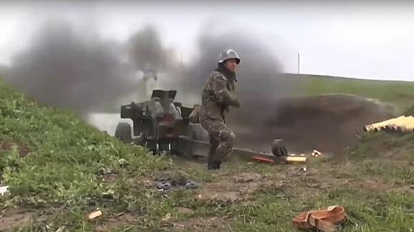 an Armenian serviceman fires a cannon an Armenian serviceman fires a cannon