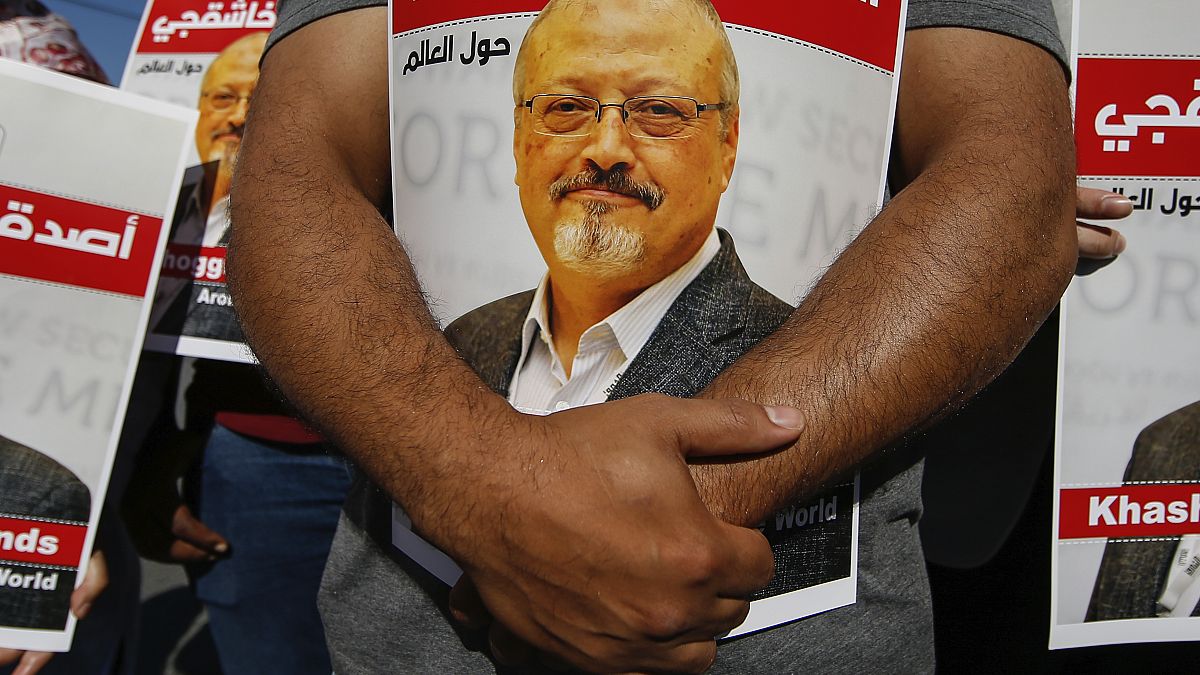 أشخاص يحملون ملصقات للصحفي السعودي جمال خاشقجي بعد مرور عامين على مقتله، بالقرب من القنصلية السعودية في اسطنبول