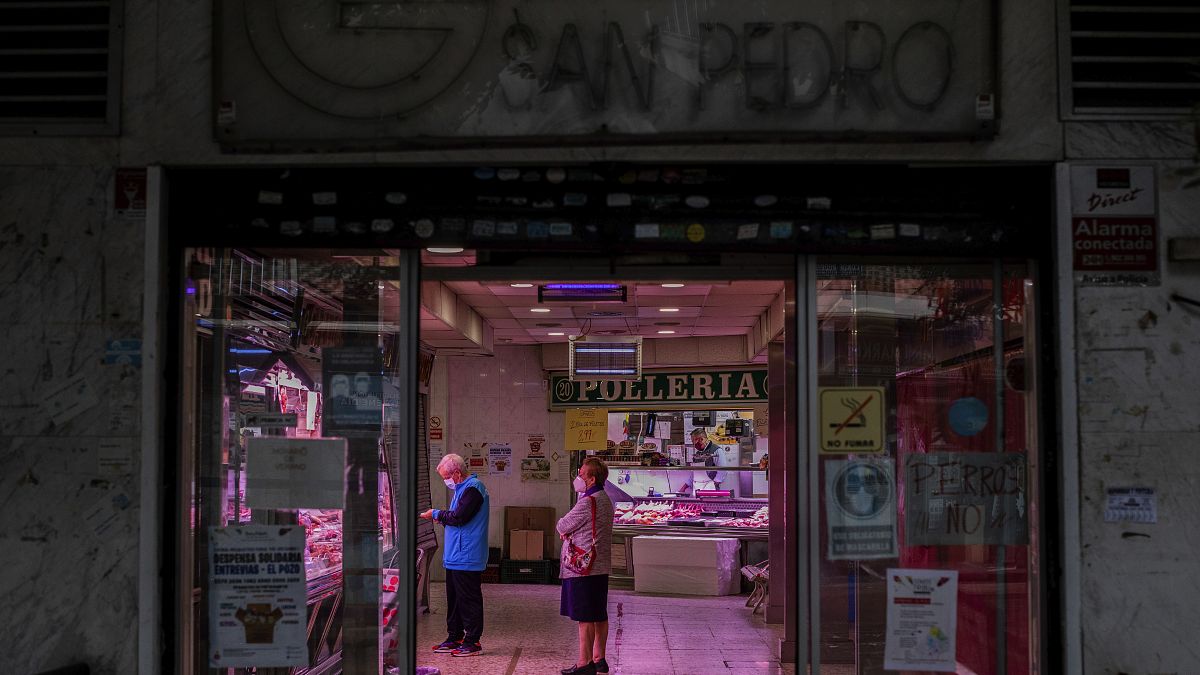 Two customers wearing face masks inside a food market in Madrid