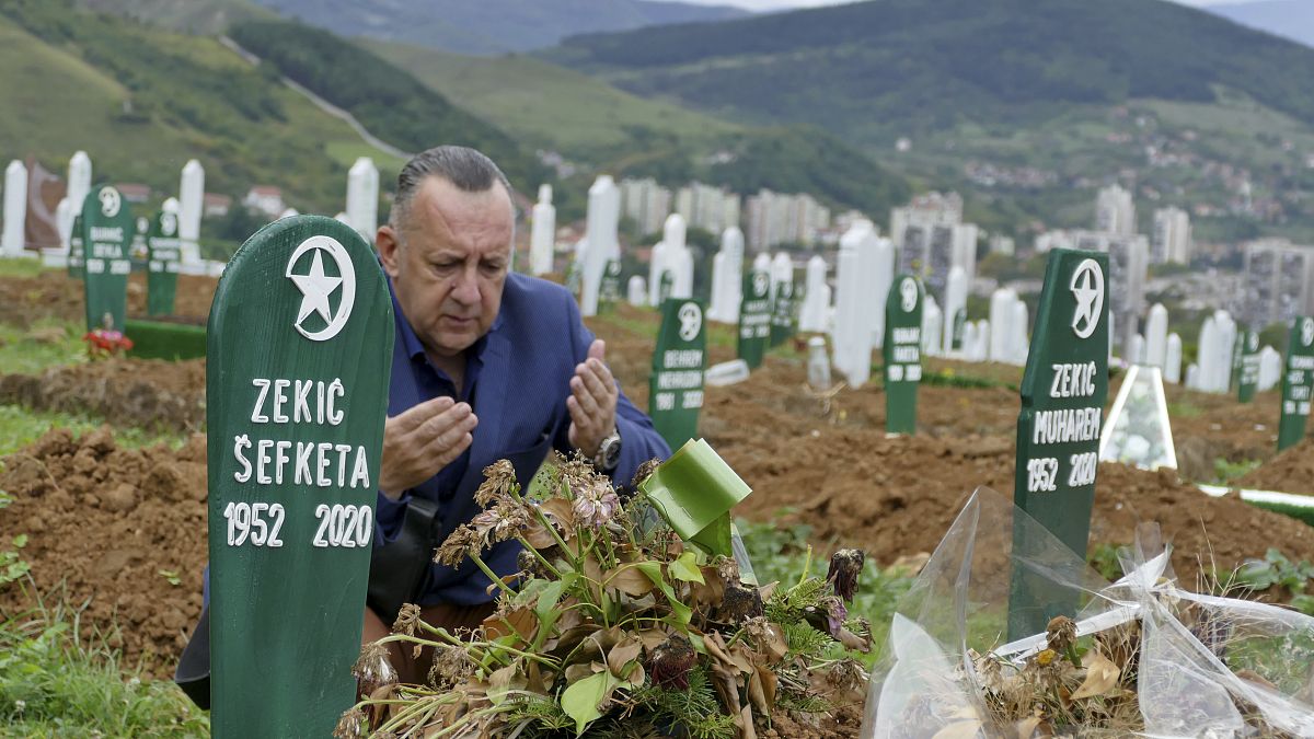 Tarik Svraka visits the graves of his parents in law who died of COVID-19 related complications, in Zenica, Bosnia, Monday, Sept. 28, 2020. 