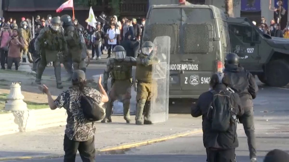 Carabineros se protegen con sus escudos durante la protesta en Santiago