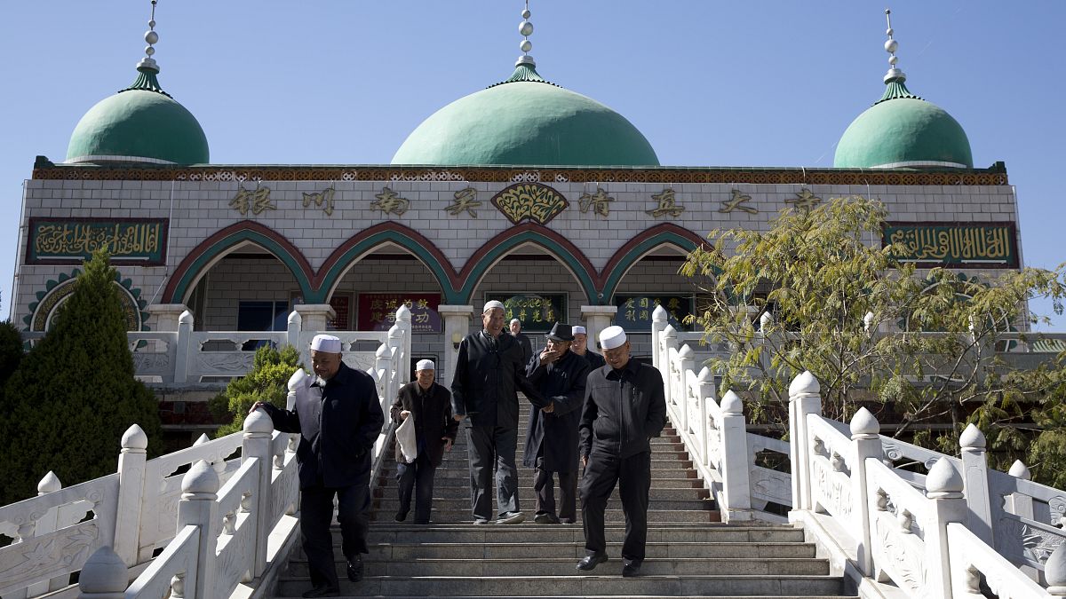  أقلية الهوي أمام مسجد في ينتشوان بمنطقة نينغشيا ذاتية الحكم في شمال غرب الصين.