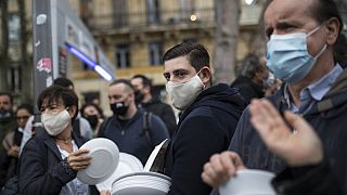 Restaurant and bar owners bang plates together and chant at a demonstration against restaurant and bar closures in Marseille, southern France, Friday Oct. 2, 2020.