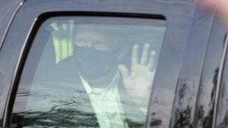 President Donald Trump drives past supporters gathered outside Walter Reed National Military Medical Center in Bethesda