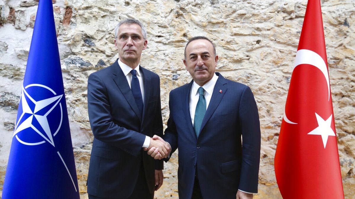 Turkish Foreign Minister Mevlut Cavusoglu, right, shakes hands with NATO Secretary General Jens Stoltenberg 
