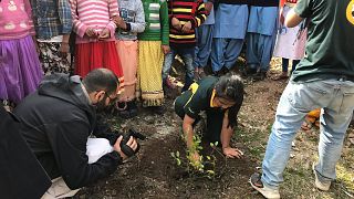 Licipriya planting a tree with a group of children.