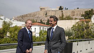 Microsoft President Brad Smith, left, speaks with Greek Prime Minister Kyriakos Mitsotakis