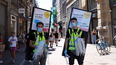 Dos voluntarios ofrecen mascarillas obligatorias en Ámsterdam