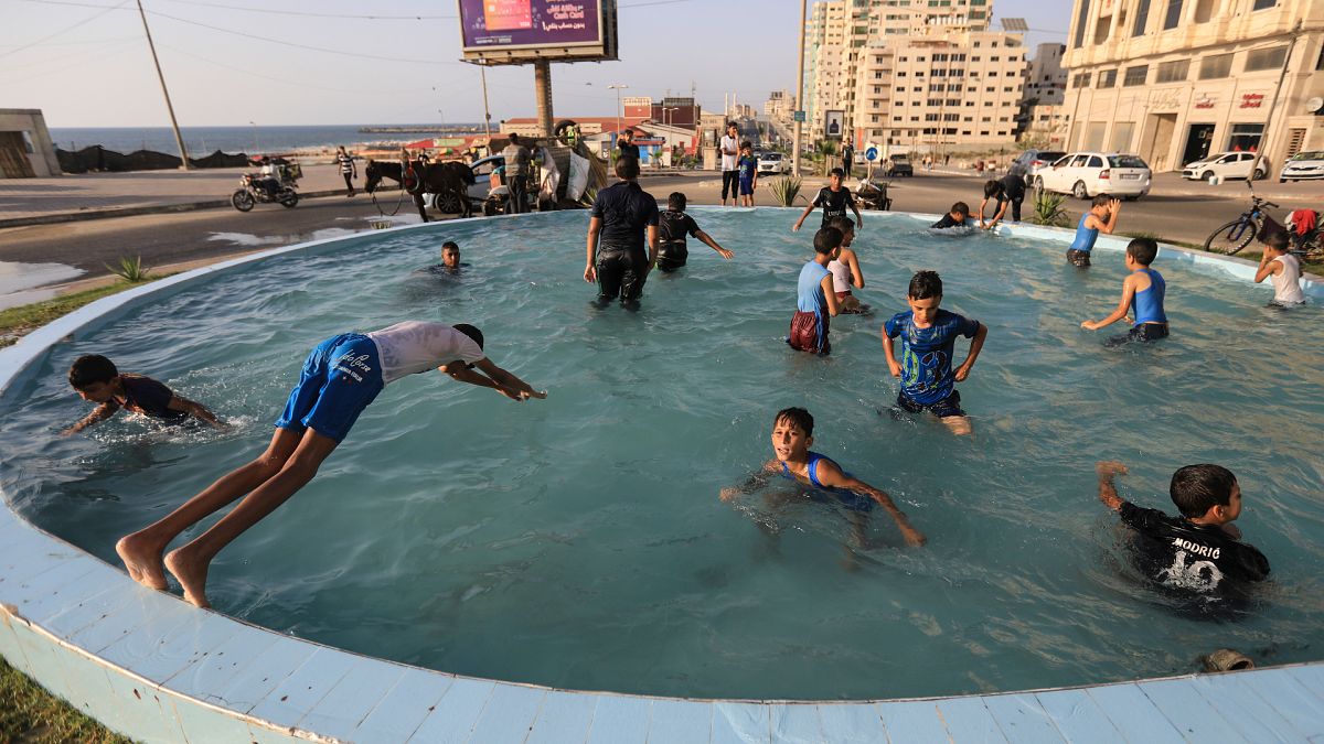 أطفال يسبحون في إحدى نوافير غزة 