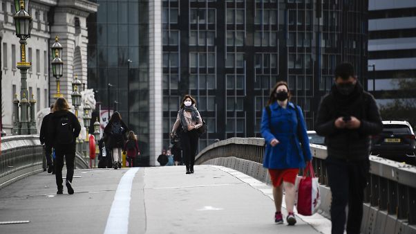 People wearing face masks walk across Westminster Bridge, in London, Wednesday, Oct. 7, 2020. People wearing face masks walk across Westminster Bridge, in London, Wednesday, Oct. 7, 2020.