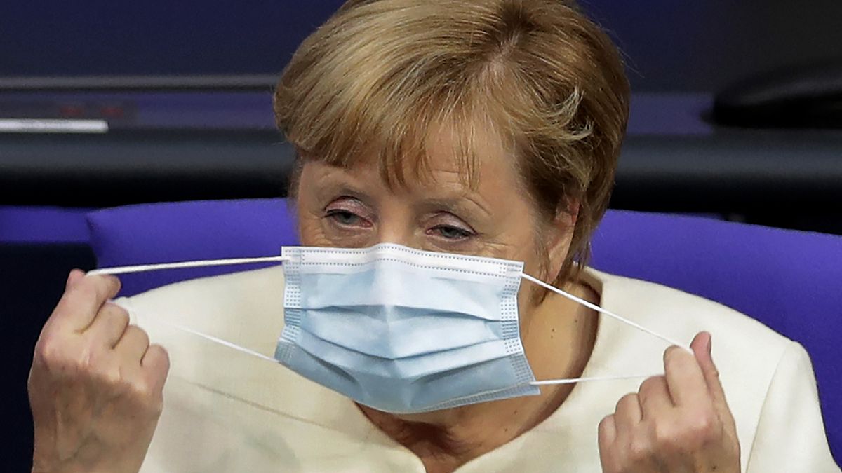German Chancellor Angela Merkel adjusts her face mask. Berlin, Germany, September 29, 2020. 