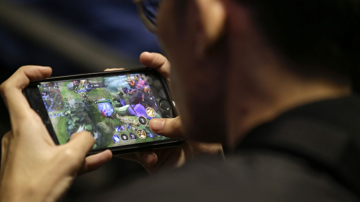 لاعب يلعب على هاتفه الذكي خلال جولات التصفيات لفريق ألعاب الفيديو الإلكترونية الفلبينية في العاصمة مانيلا. 