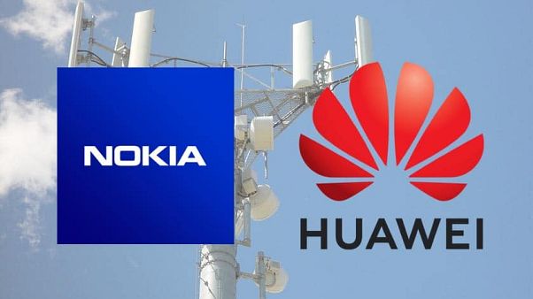 Baz istasyonu önünde Nokia ve Huawei logoları Baz istasyonu önünde Nokia ve Huawei logoları