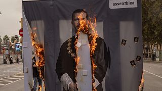 Activists of Catalonia's pro-independence grassroots group, ANC, burn a portrait of Spain's King Felipe VI during a demonstration in Barcelona on Friday, October 9, 2020.