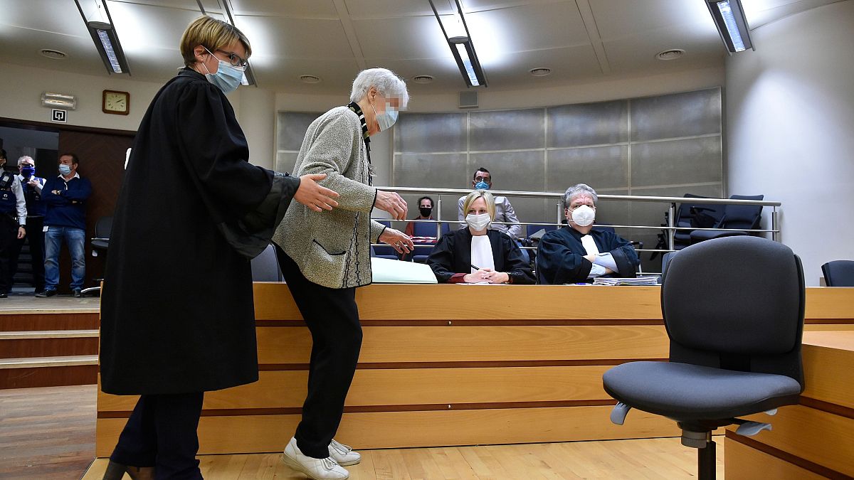 Clara Maes, 89, is helped to her seat in the courtroom where she was found guilty of murder