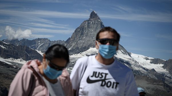 Touristen mit Mundschutz vor dem Matterhorn. Touristen mit Mundschutz vor dem Matterhorn.