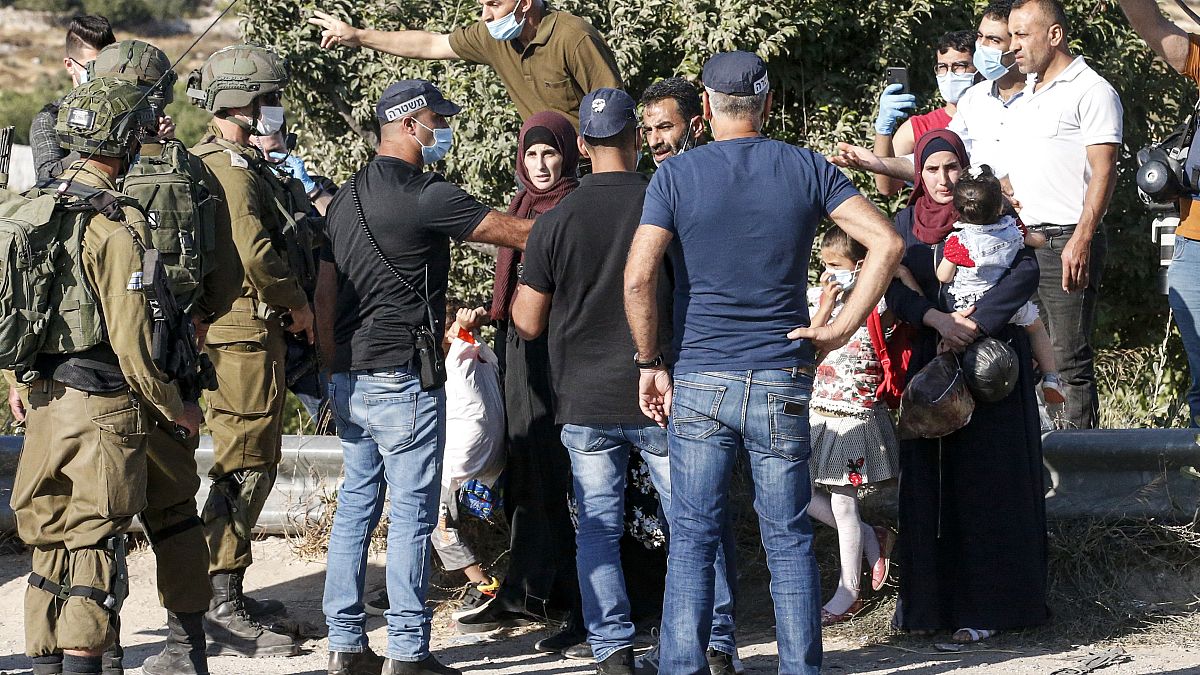 جنود وعناصر شرطة إسرائيليون يمنعون فلسطينيين من المضي في طريقهم في الضفة الغربية
