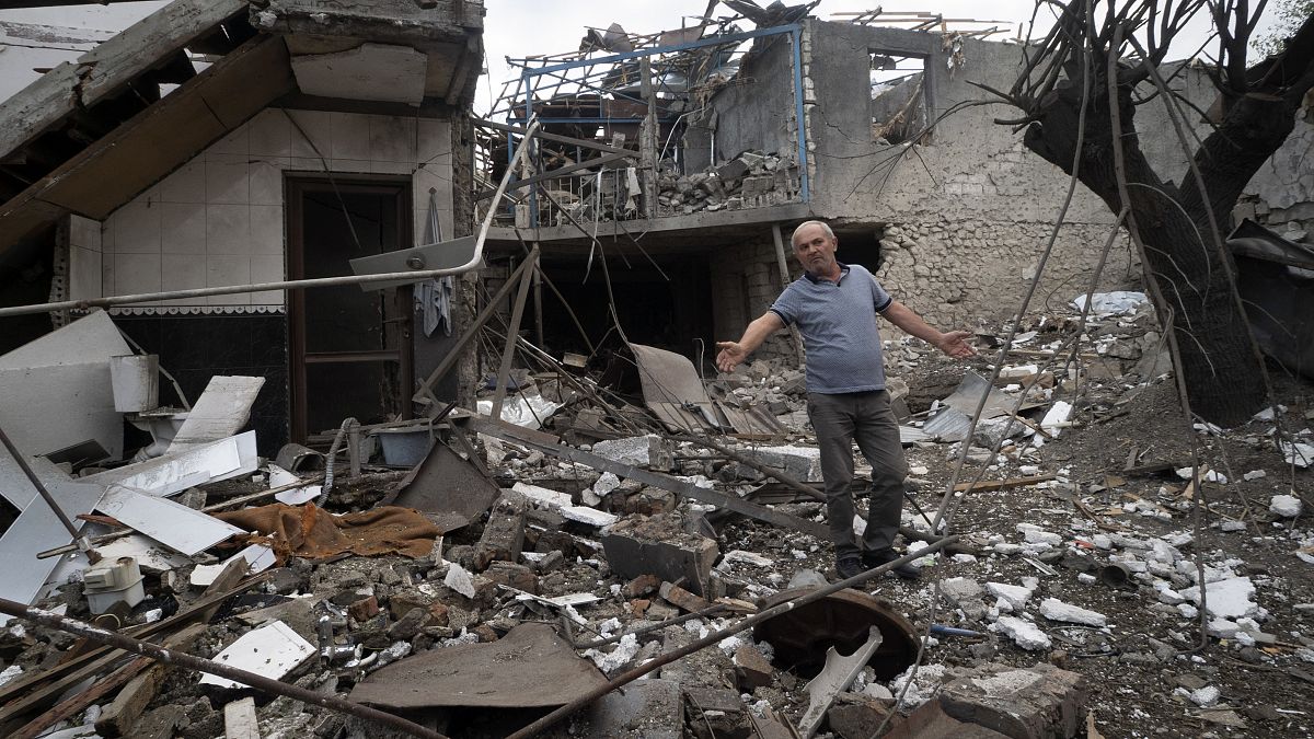 A man gestures in the yard of a house destroyed by shelling by Azerbaijan's artillery during a military conflict in Stepanakert, in Nagorno-Karabakh, Oct. 9, 2020.